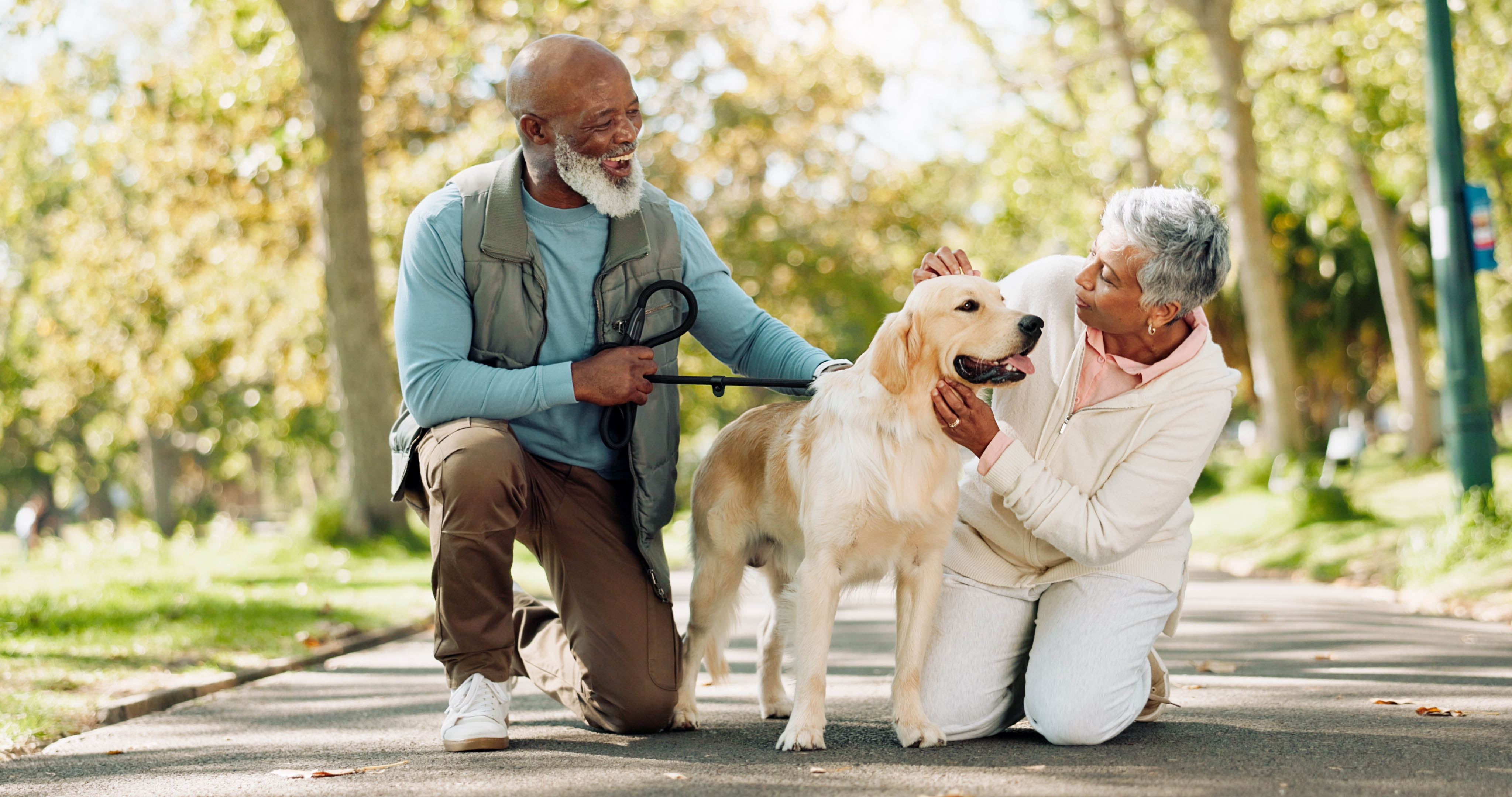 Older couple outside on a walk, petting their dog